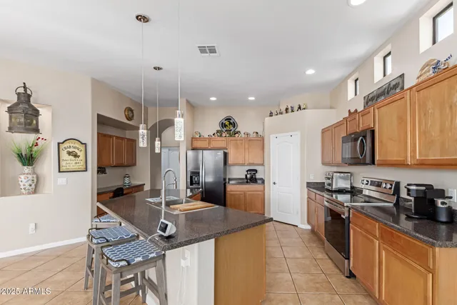 a kitchen with stainless steel appliances granite countertop a refrigerator and a stove