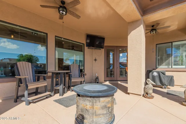 a view of a patio with a table and chairs under an umbrella