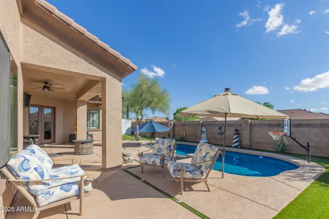 a view of a house with swimming pool and sitting area