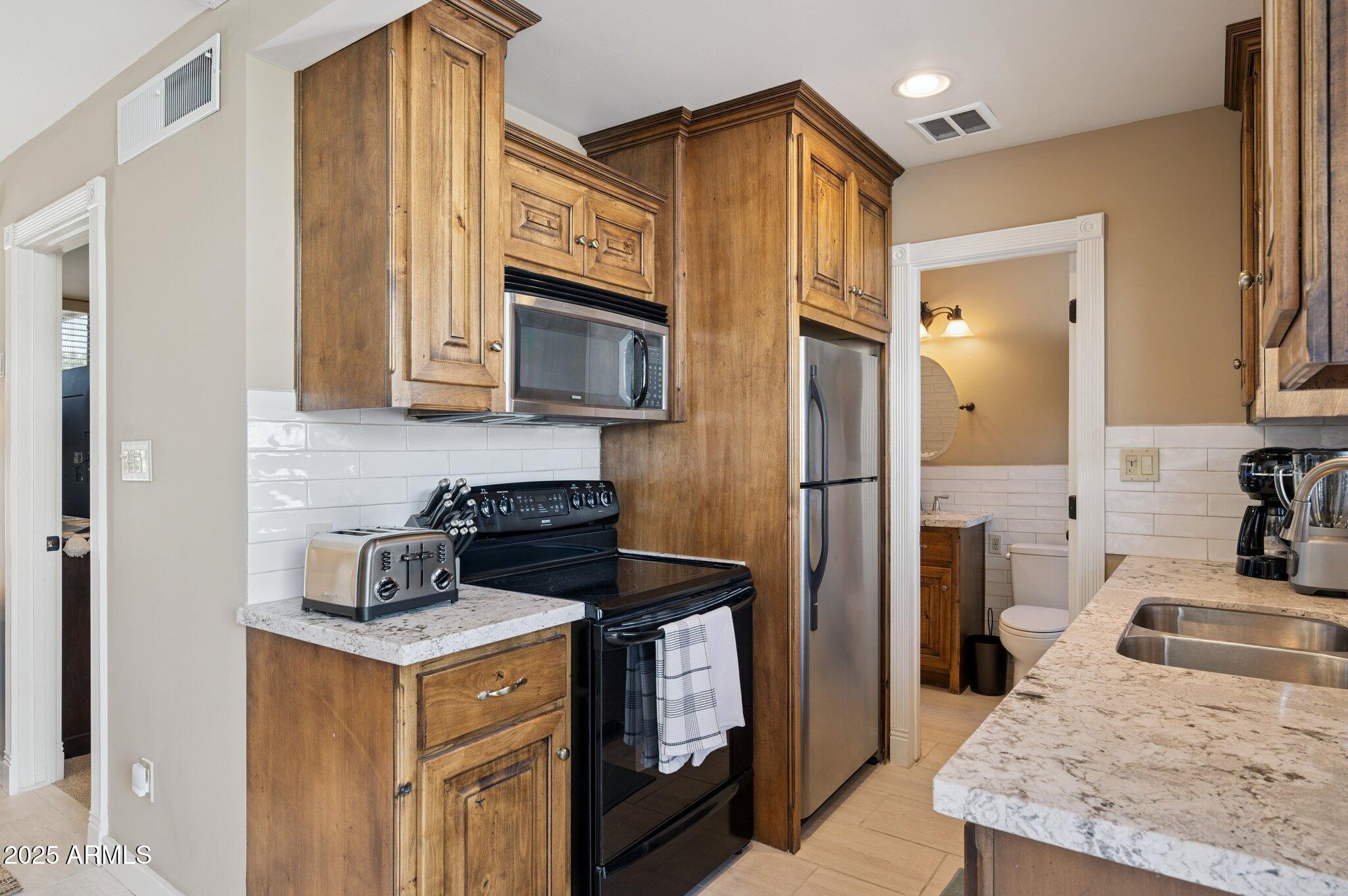 4208 North 38th Street, Unit 2 Phoenix, AZ 85018 - Photo 9 of 20 a kitchen with stainless steel appliances granite countertop a refrigerator a stove top oven a sink and dishwasher