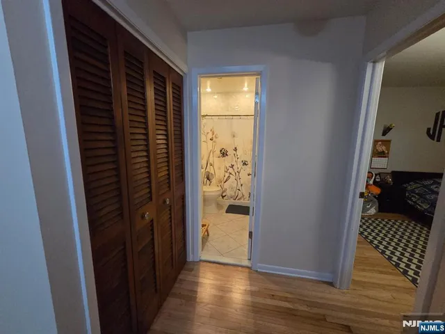 a view of hallway with wooden floor and door