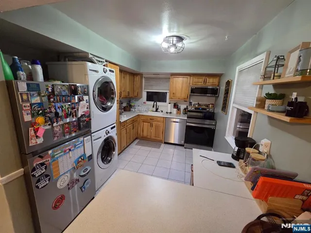 a view of a kitchen with fridge and workspace