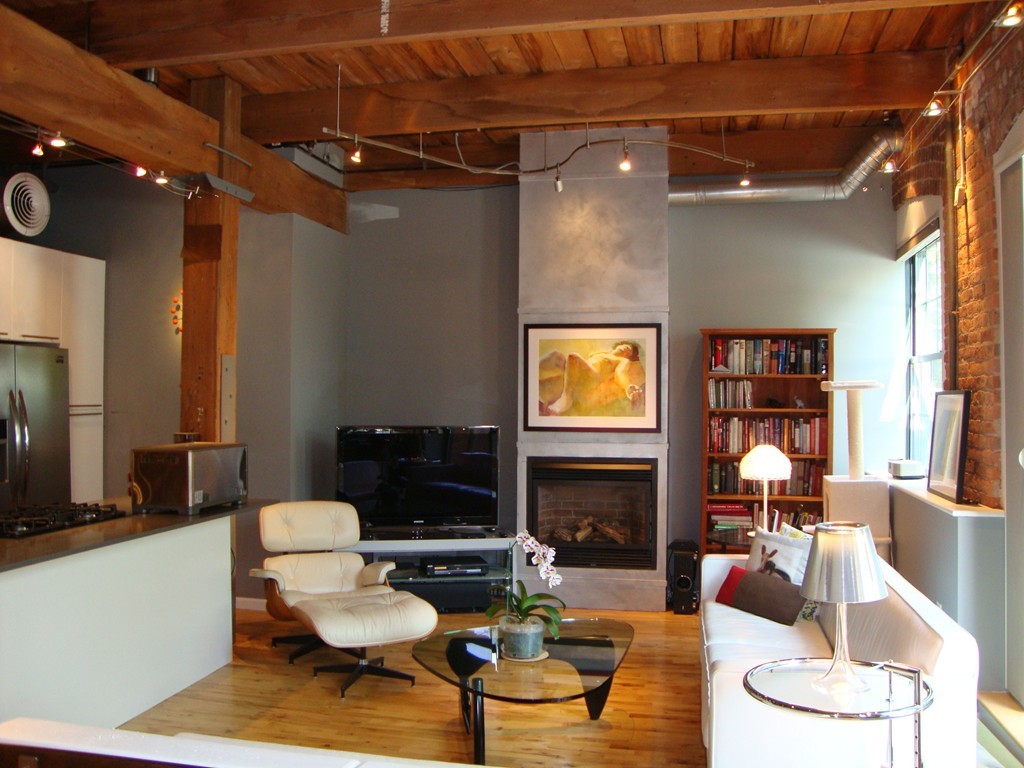 210 Broadway, Unit 104 Everett, MA 02149 - Photo 3 of 13 a living room with furniture and a fireplace