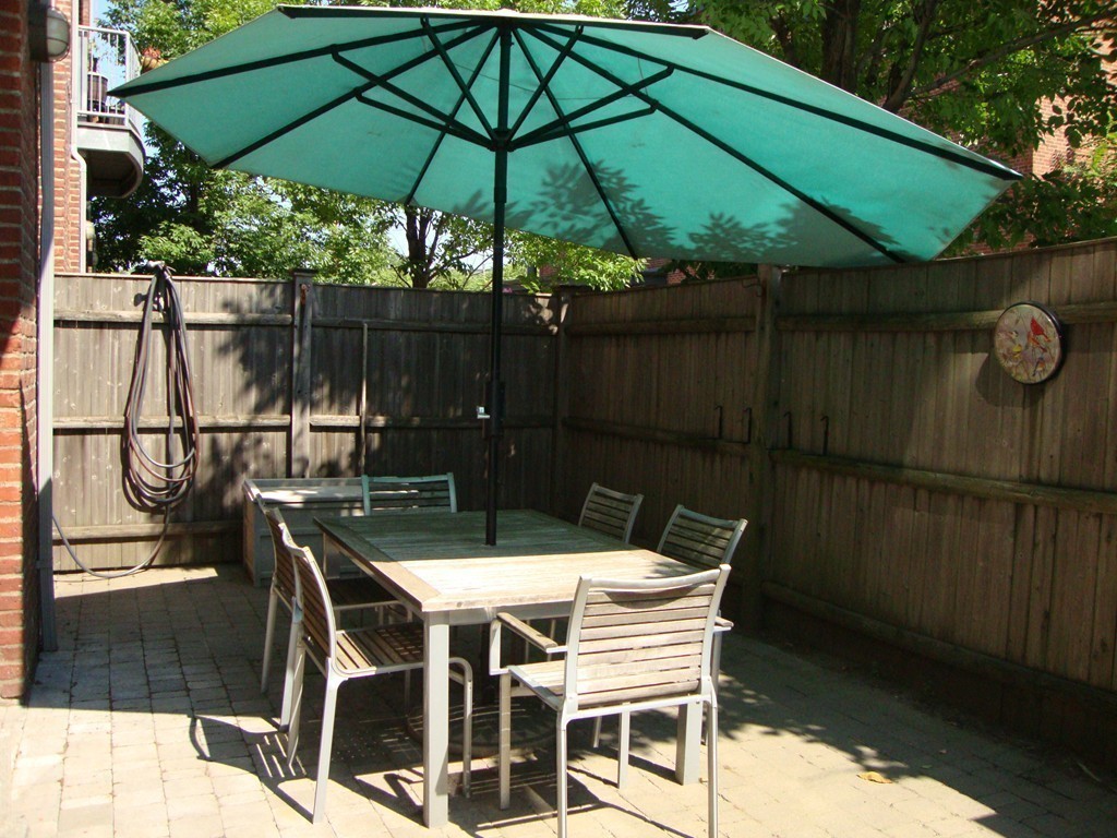 210 Broadway, Unit 104 Everett, MA 02149 - Photo 8 of 13 a patio with wooden floor a yard table and chairs