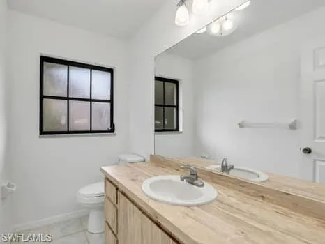 a bathroom with a granite countertop sink toilet and mirror