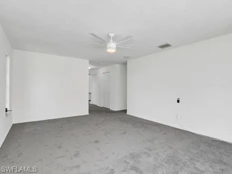 an empty room with a ceiling fan and a fan