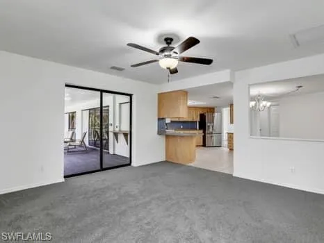 a view of an empty room with a kitchen