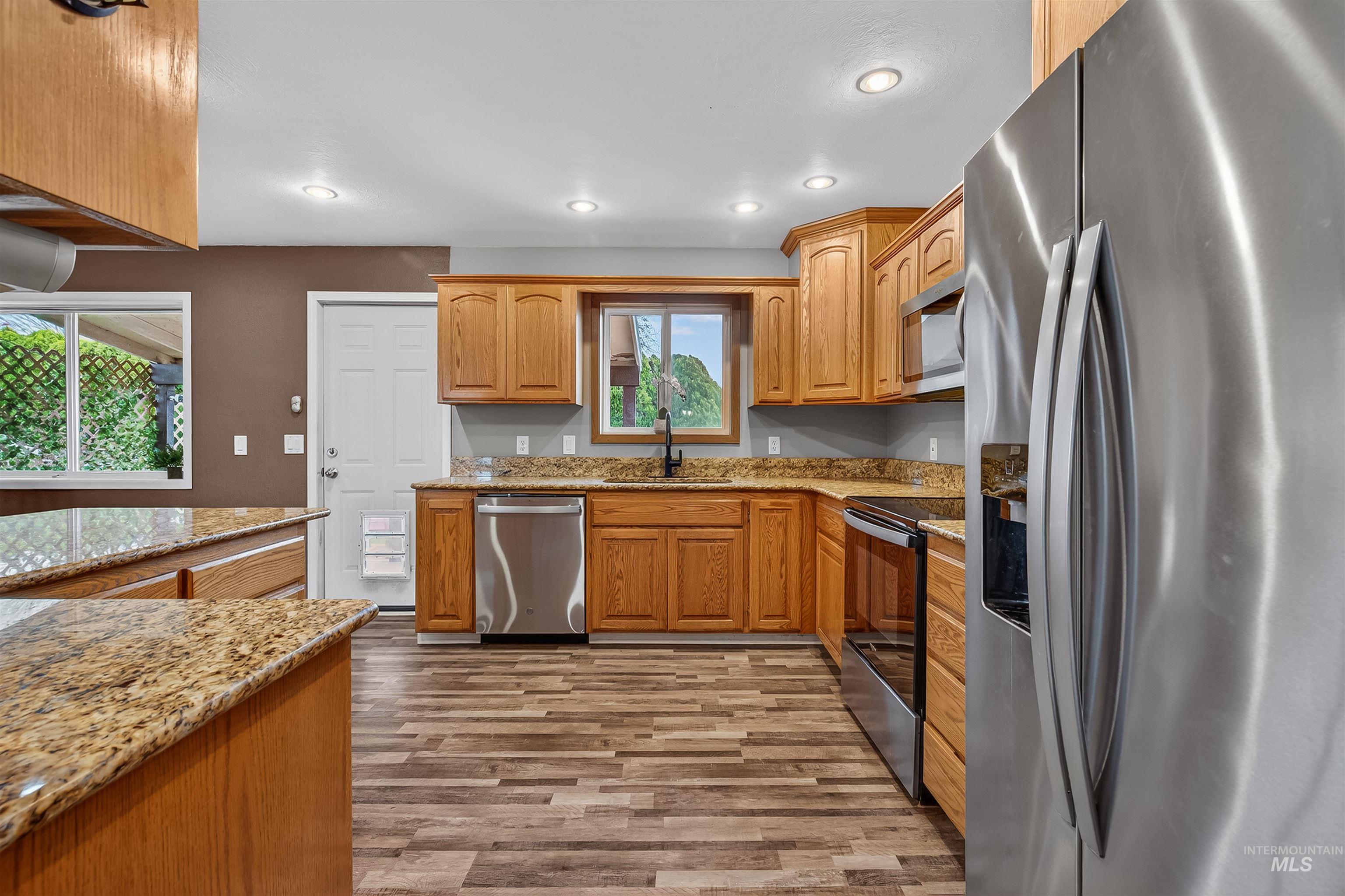 3725 11th Street Lewiston, ID 83501 - Photo 12 of 46 Kitchen featuring stainless steel appliances, light stone countertops, light wood-type flooring, recessed lighting, and wood finish cabinetry