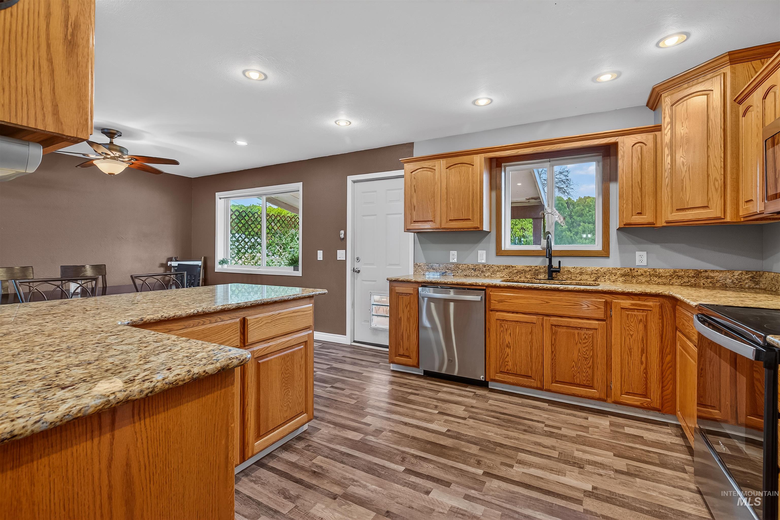 3725 11th Street Lewiston, ID 83501 - Photo 13 of 46 Kitchen with light stone counters, black electric range, stainless steel dishwasher, light wood-style flooring, and wood finish cabinets