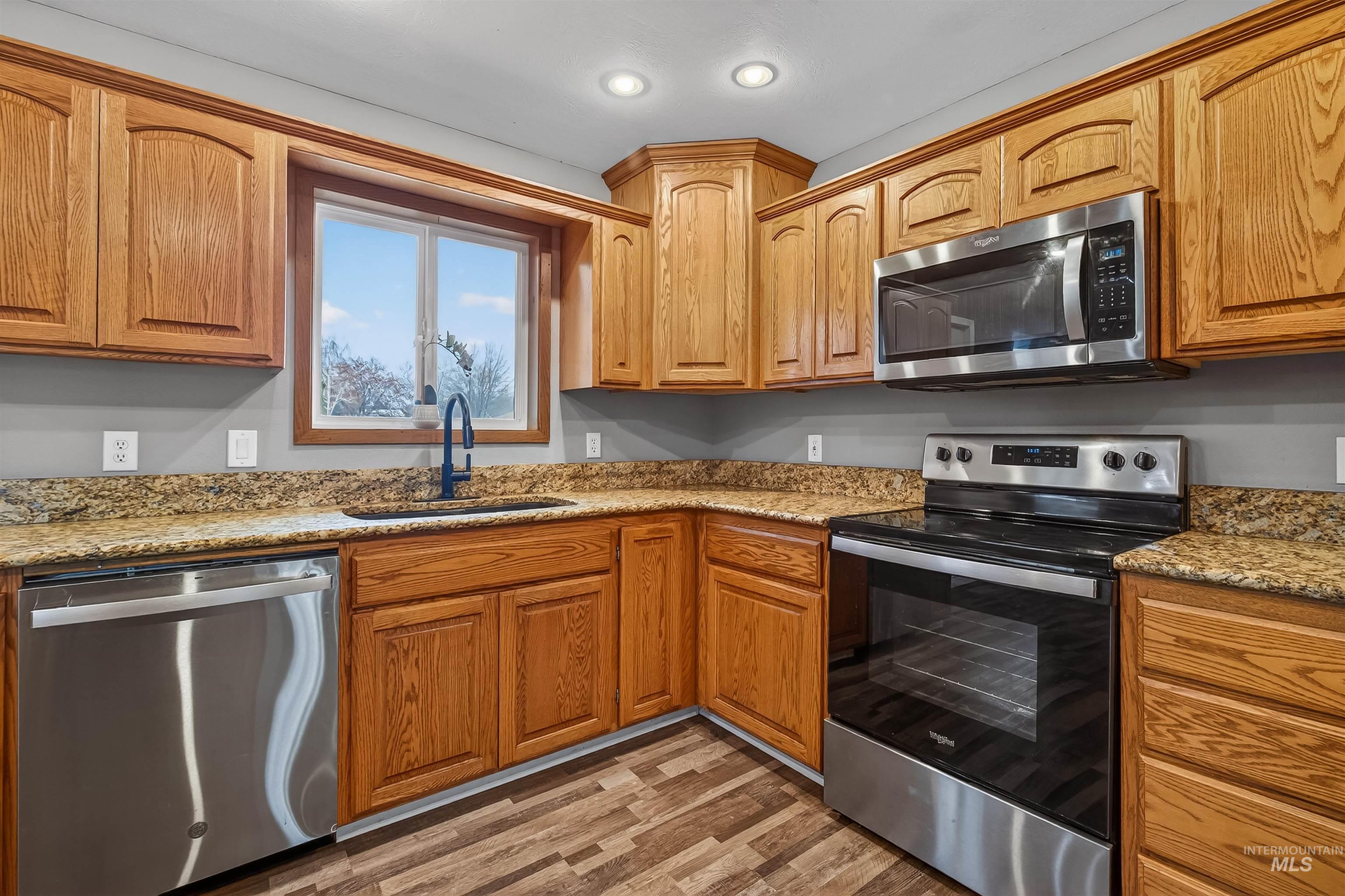 3725 11th Street Lewiston, ID 83501 - Photo 15 of 46 Kitchen featuring stainless steel appliances, light stone counters, light wood-type flooring, and wood finish cabinetry