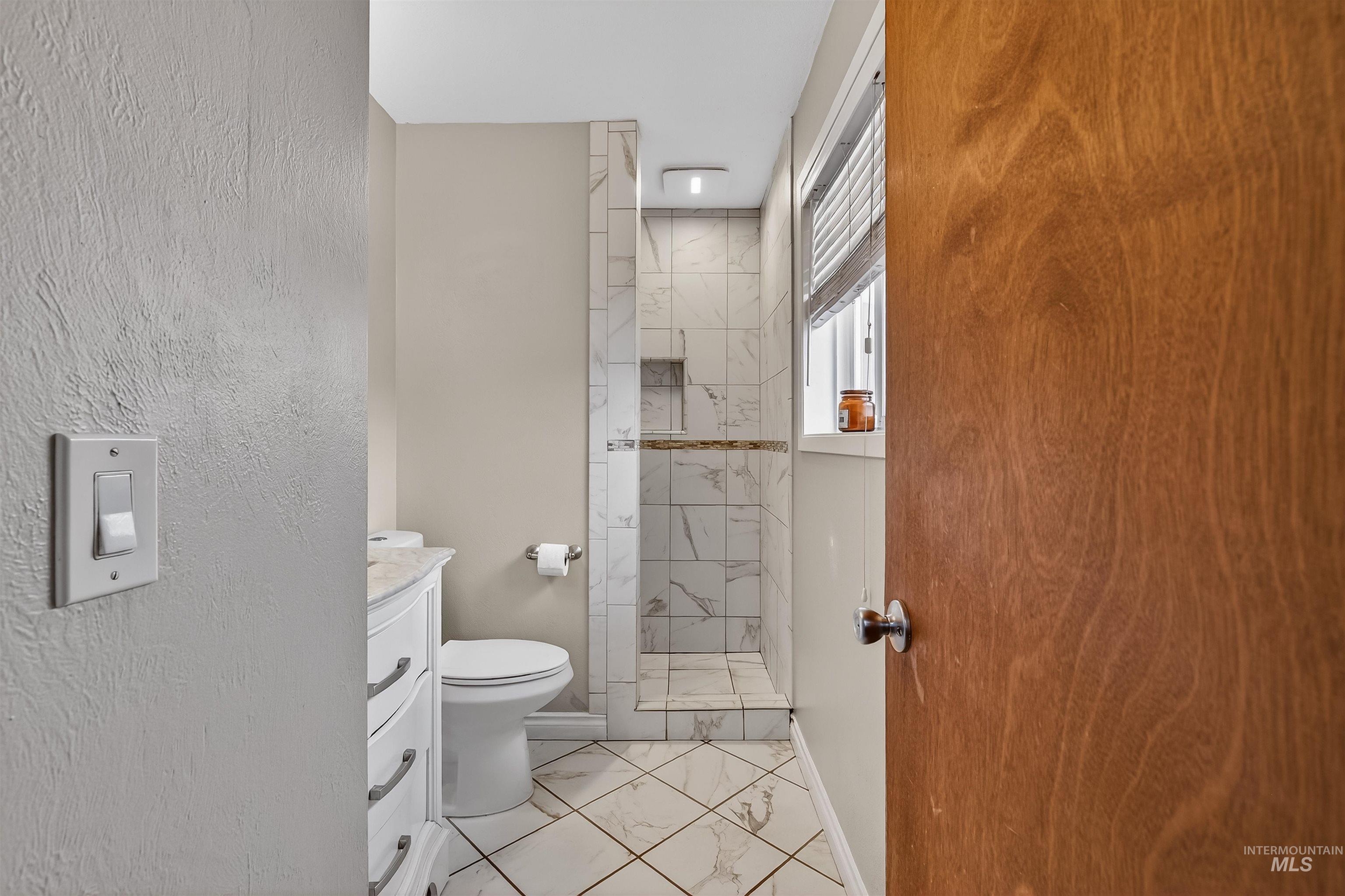 3725 11th Street Lewiston, ID 83501 - Photo 20 of 46 Full bath featuring a marble finish shower, vanity, a textured wall, and light marble finish floors