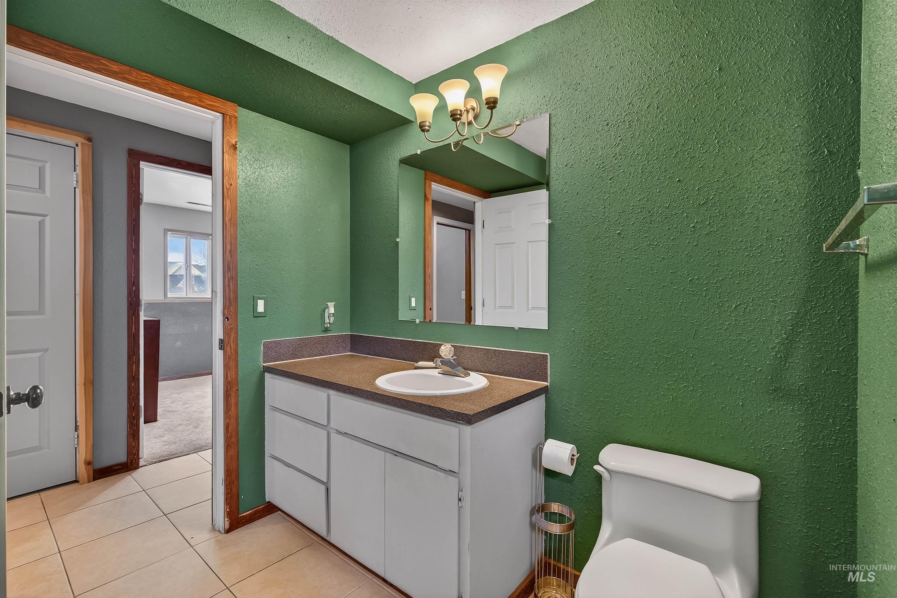 3725 11th Street Lewiston, ID 83501 - Photo 31 of 46 Bathroom with a textured wall, vanity, hanging lights, and light tile patterned floors