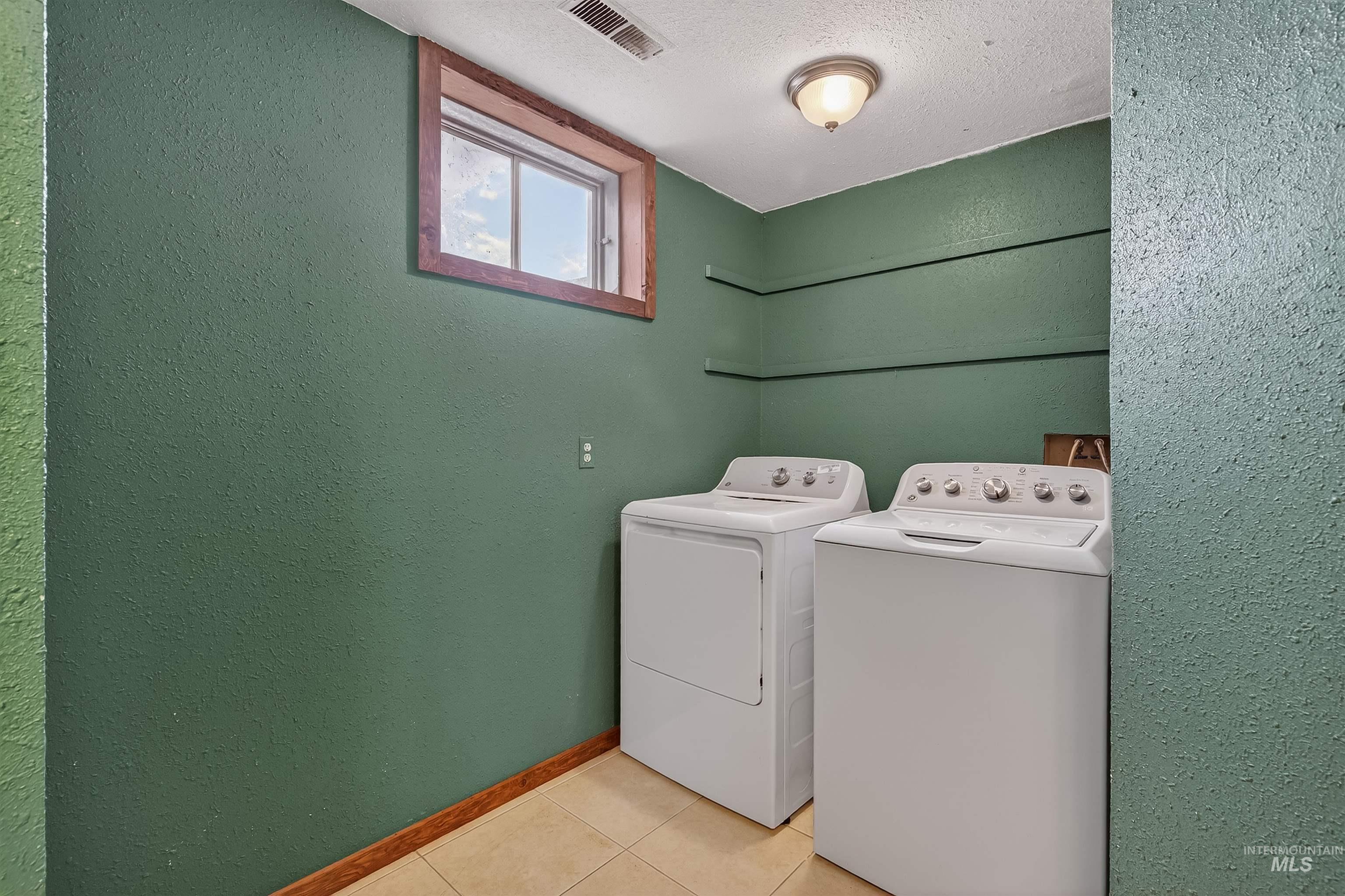 3725 11th Street Lewiston, ID 83501 - Photo 32 of 46 Laundry room with a textured wall, a textured ceiling, washing machine and clothes dryer, and light tile patterned floors