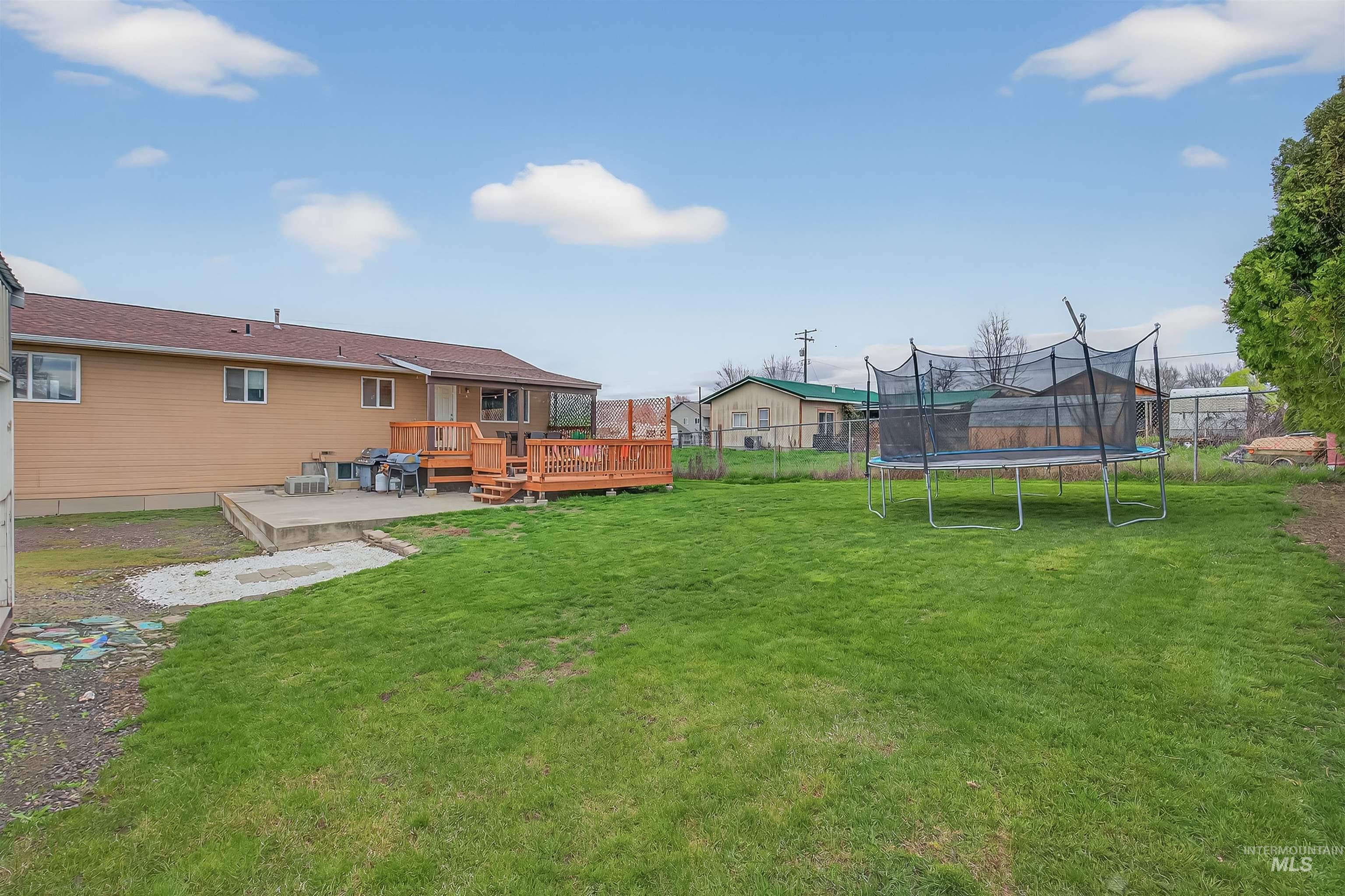 3725 11th Street Lewiston, ID 83501 - Photo 41 of 46 Fenced backyard with a wooden deck and a trampoline