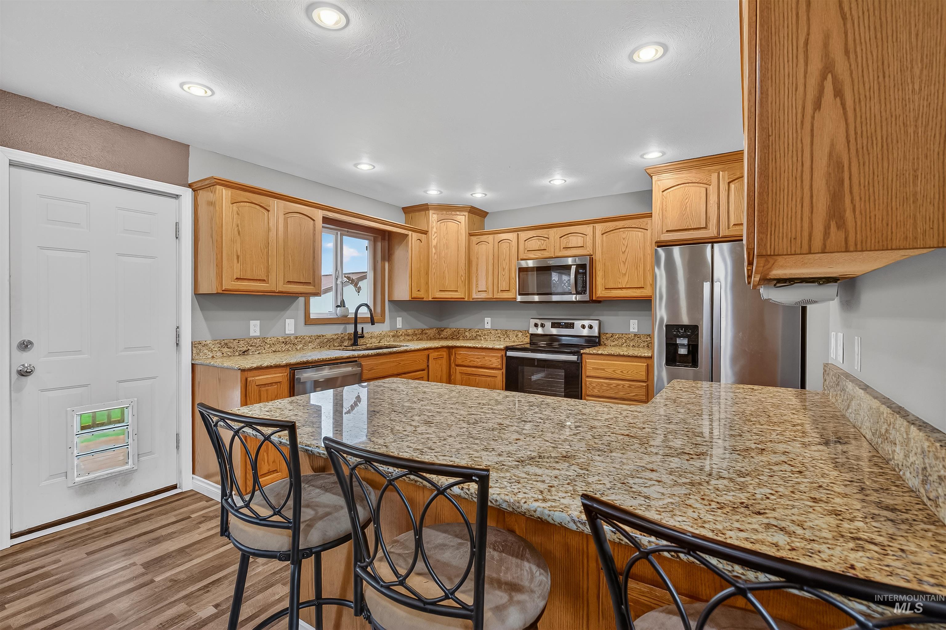 3725 11th Street Lewiston, ID 83501 - Photo 8 of 46 Kitchen featuring stainless steel appliances, a breakfast bar area, a peninsula, light stone countertops, and recessed lighting