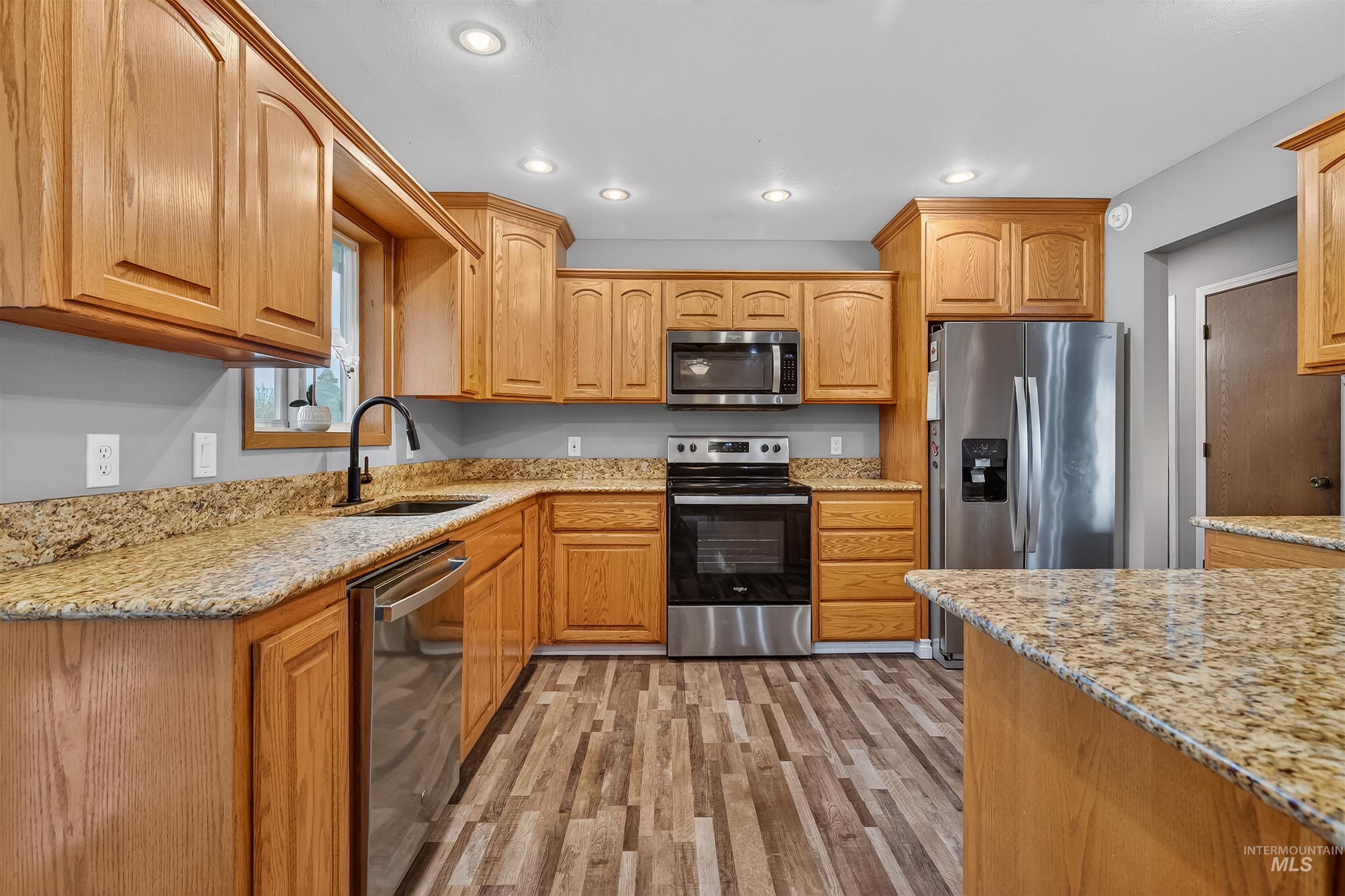 3725 11th Street Lewiston, ID 83501 - Photo 10 of 46 Kitchen featuring stainless steel appliances, light stone countertops, light wood-style flooring, recessed lighting, and wood finish cabinets