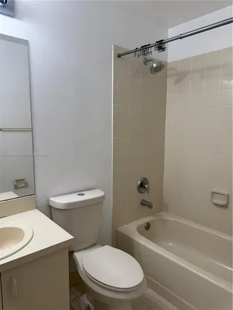 a white toilet and tub sitting next to a bathroom sink