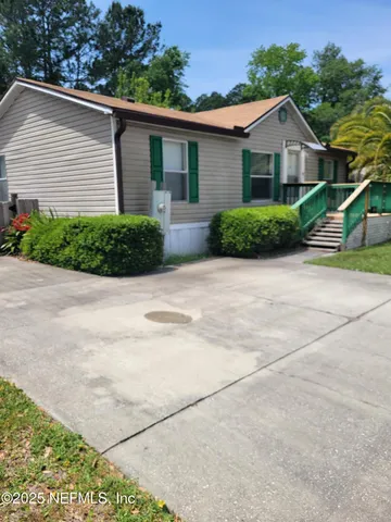 a front view of a house with yard and green space