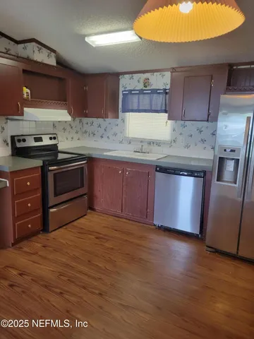 a kitchen with stainless steel appliances granite countertop a stove a sink and a refrigerator