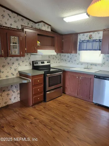 a kitchen with stainless steel appliances granite countertop a stove a sink and a microwave
