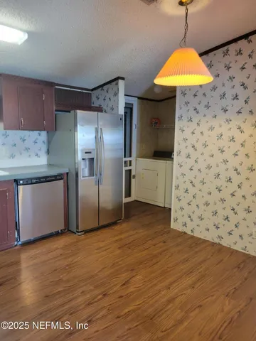 a kitchen that has a lot of cabinets and wooden floor