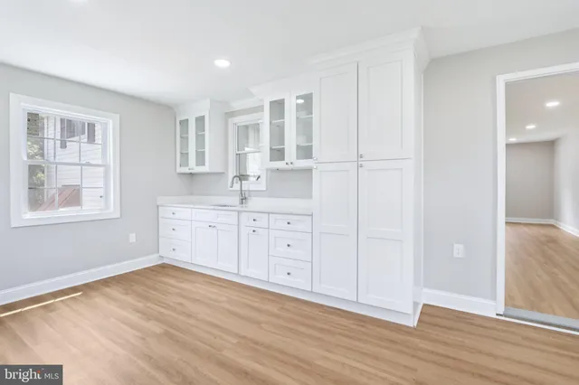 a view of a kitchen with wooden floor and windows