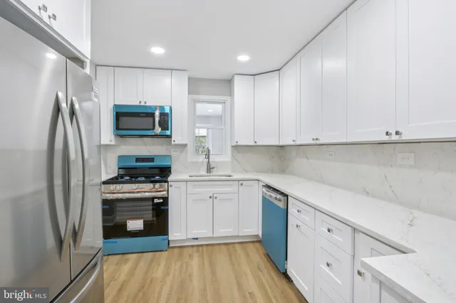 a kitchen with cabinets stainless steel appliances and a counter space