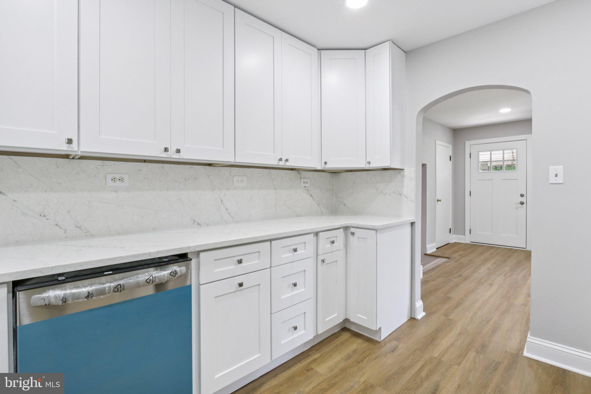1 Russell Road New Castle, DE 19720 - Photo 20 of 49 a kitchen with white cabinets and a stove with wooden floors