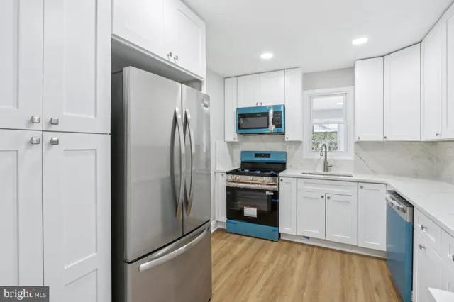 a kitchen with stainless steel appliances a refrigerator stove and sink