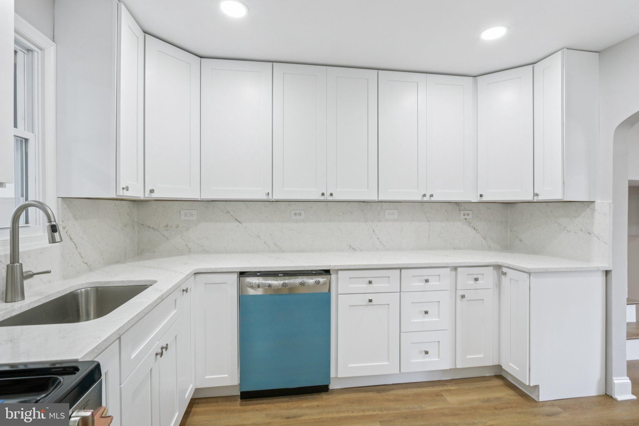 1 Russell Road New Castle, DE 19720 - Photo 22 of 49 a kitchen with white cabinets and a sink