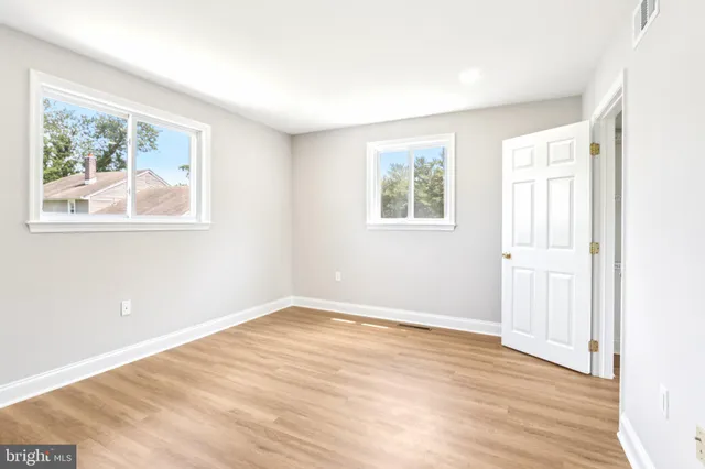 an empty room with wooden floor and window