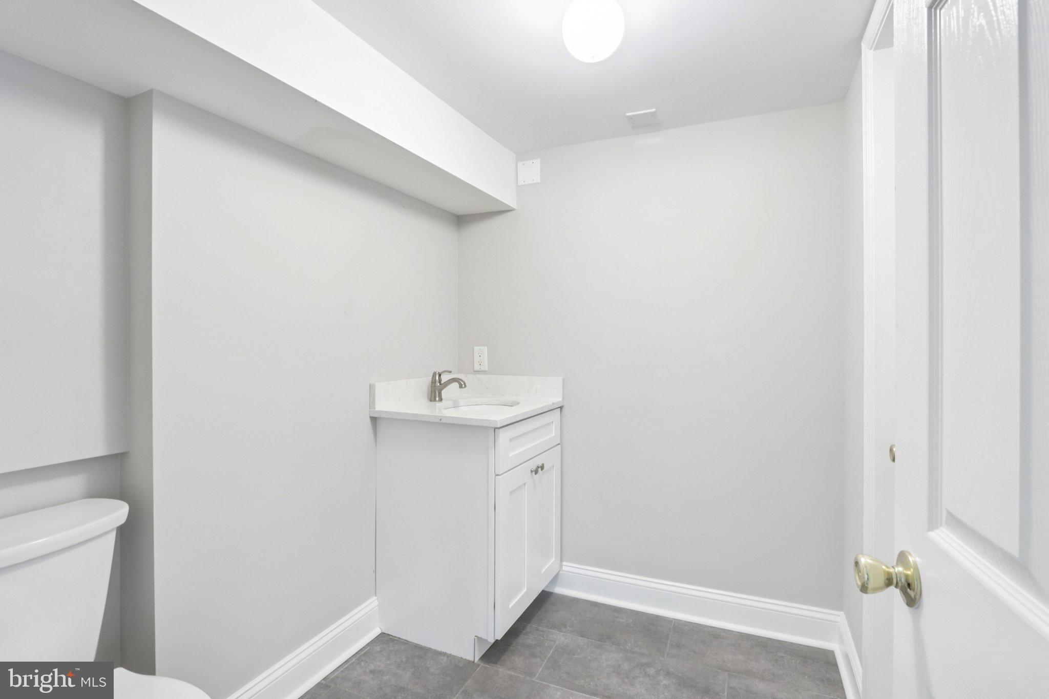 1 Russell Road New Castle, DE 19720 - Photo 37 of 49 a bathroom with a sink a toilet and vanity