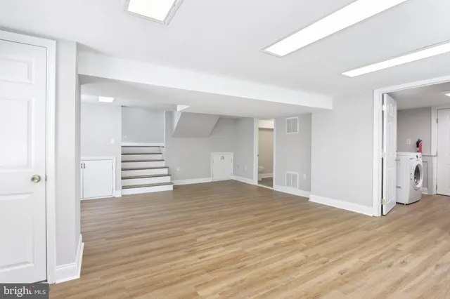 a view of empty room with wooden floor and entryway