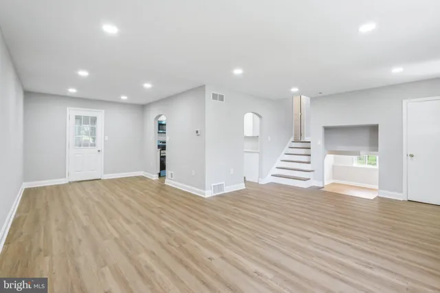 a view of empty room with wooden floor