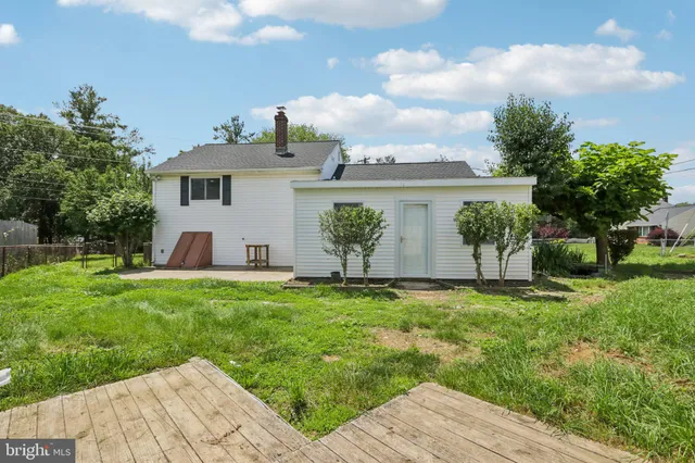 a view of a white house with a yard and potted plants