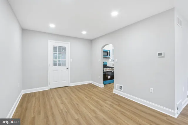 a view of empty room with wooden floor