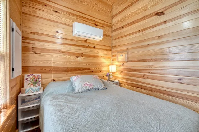 a room with a flat screen tv on dresser and a window