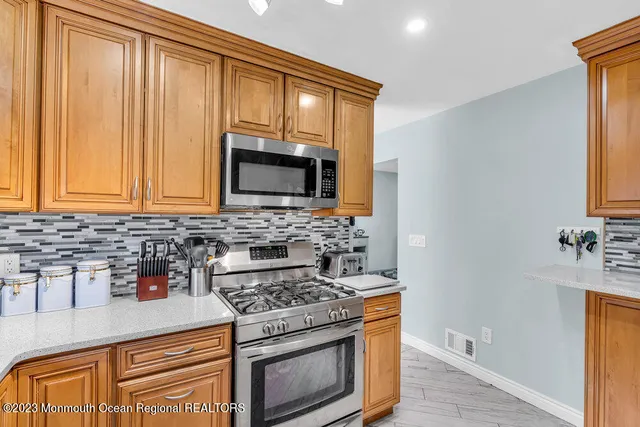 a kitchen with granite countertop cabinets stainless steel appliances and wooden floor