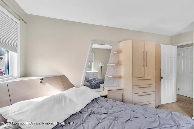 a bedroom with a white bed and cabinets