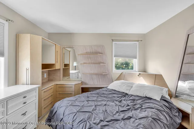 a bedroom with a bed and a large window