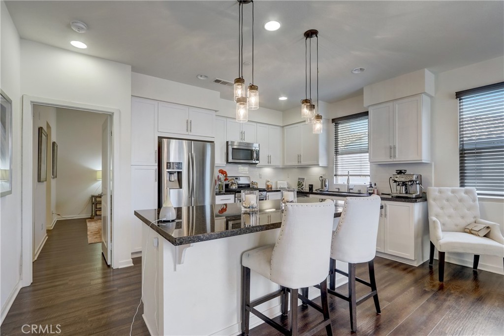 44 Hoya Street Rancho Mission Viejo, CA 92694 - Photo 8 of 32 a kitchen with refrigerator cabinets dining table and chairs