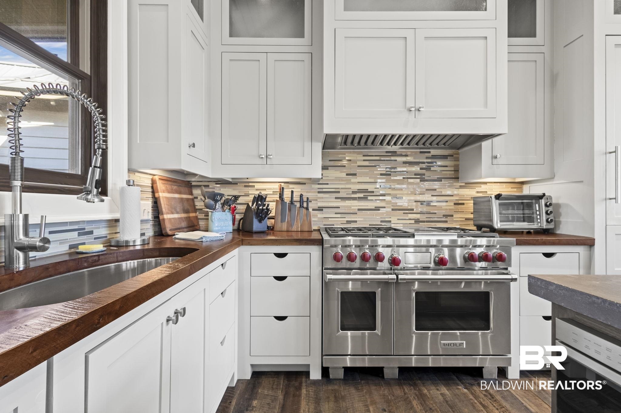 15020 River Road Fairhope, AL 36532 - Photo 4 of 59 Kitchen featuring decorative backsplash, double oven range, and white cabinets