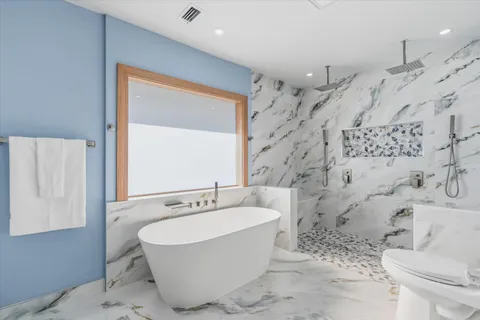 a bathroom with a sink a toilet and shower