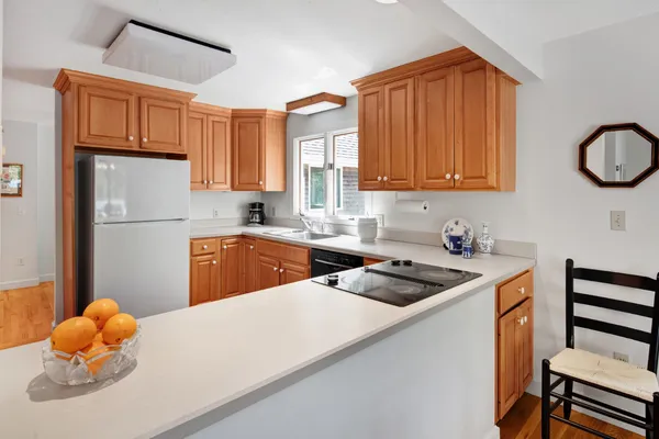 a kitchen with stainless steel appliances granite countertop a sink dishwasher stove and refrigerator with wooden floor