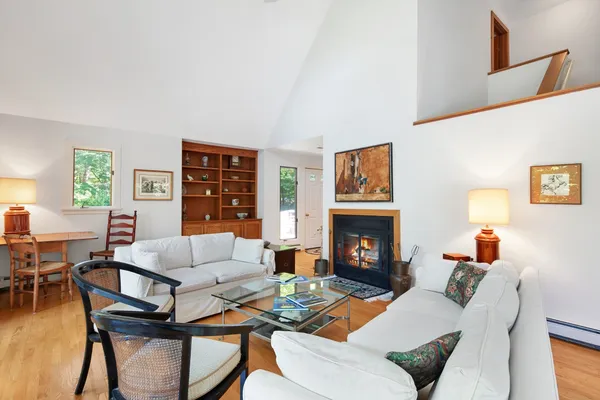 a living room with furniture a fireplace and a large window