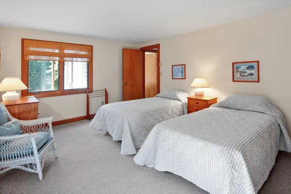 a bedroom with two beds and a large window