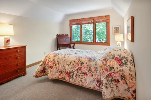 a bed sitting in a bedroom next to a window