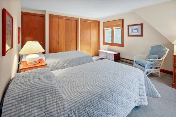 a bedroom with a bed a lamp and a window