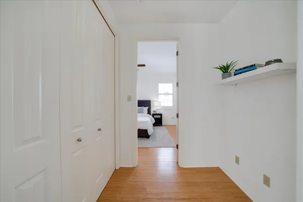 a view of a hallway with wooden floor and a living room