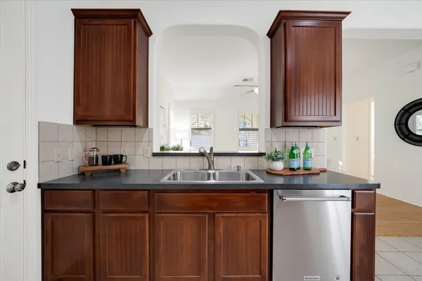 a kitchen with granite countertop a sink stove and cabinets